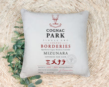 Load image into Gallery viewer, Indoor Outdoor Pillows Cognac Park Label Print on rug